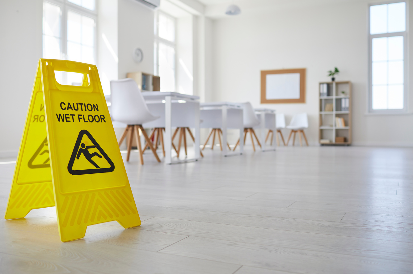 Yellow Sign That Reads Caution Wet Floor Standing in Clean Empty School Classroom